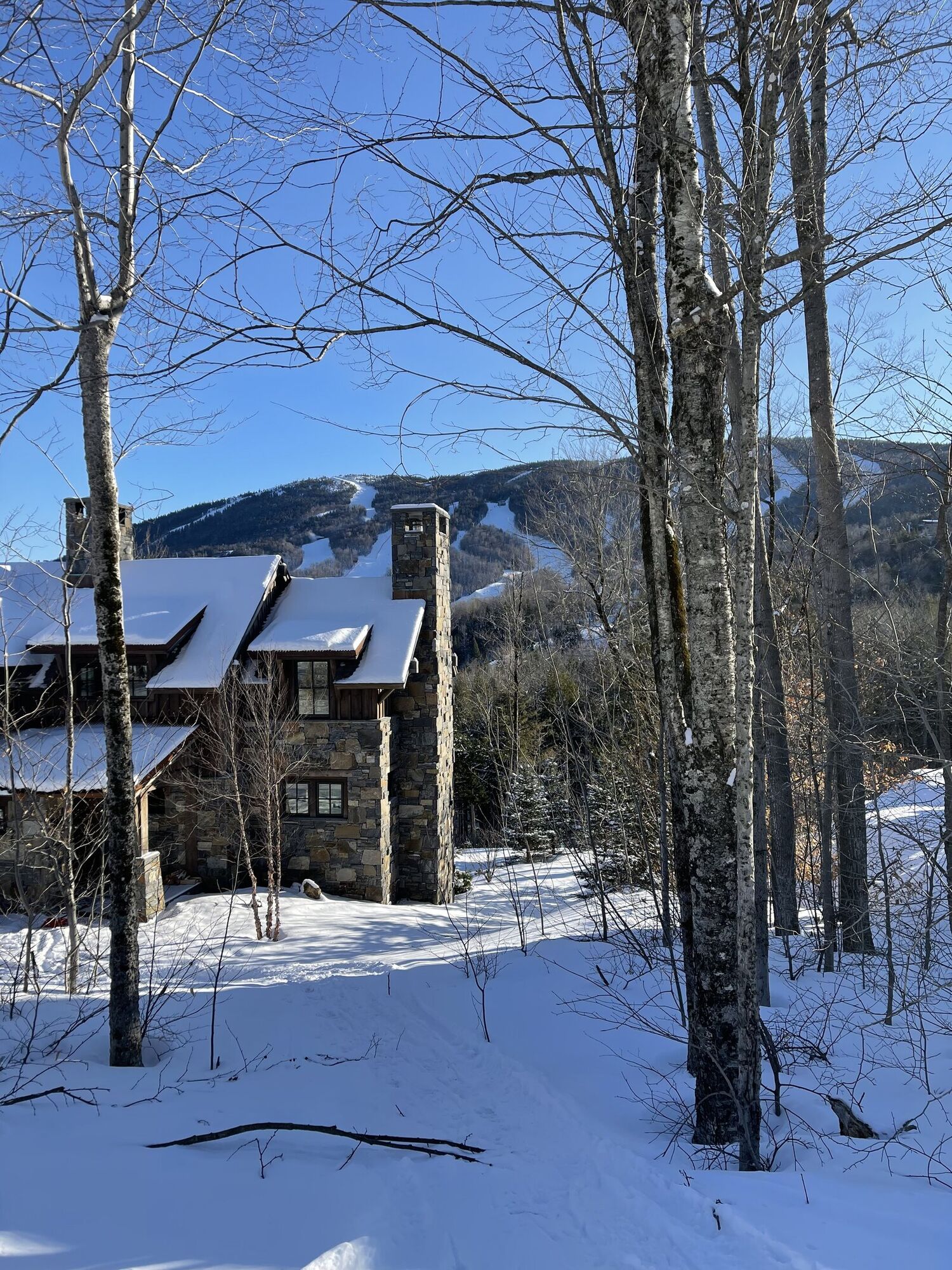 Stone mountain lodge with ski trails on the peak behind it